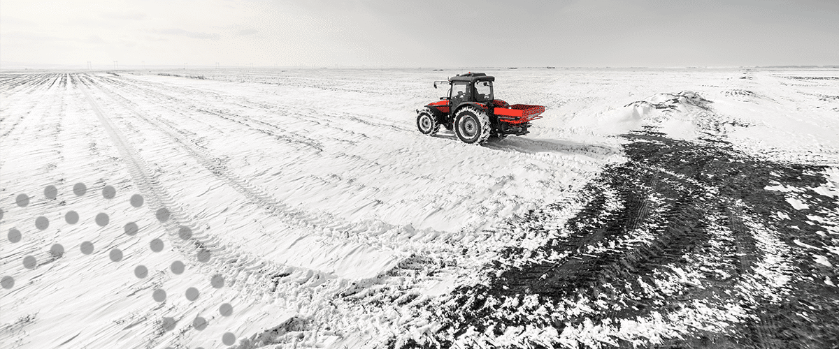 Farm machinery on a snow-covered farm field.