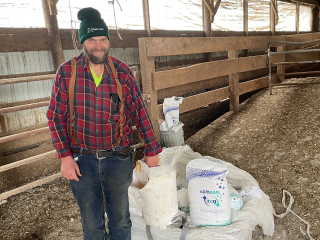 TIMAC AGRO customer next to Actisan 360 bag, part of our Animal Production solutions.